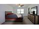 Bedroom with neutral walls, and a bed with red accents, with a ceiling fan and window at 14352 Editors Note St, Ruskin, FL 33573