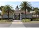 Community clubhouse with palm trees, manicured landscaping and crosswalk at 14352 Editors Note St, Ruskin, FL 33573