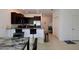 Eat-in kitchen featuring dark cabinets, bar seating, stainless appliances, and access to an office space at 14352 Editors Note St, Ruskin, FL 33573