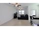 Spacious living room featuring tiled flooring, a comfortable couch, and a modern entertainment setup at 14352 Editors Note St, Ruskin, FL 33573
