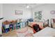 Cheerful ' bedroom with colorful decor, a cozy bed, a rainbow rug, and a window that lets in natural light at 15801 Bridgewater Ln, Tampa, FL 33624