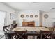 Neutral dining area with a long dark wood table and four wall decoration pieces at 15801 Bridgewater Ln, Tampa, FL 33624