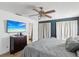 Spacious bedroom with a ceiling fan and a TV, featuring a calming color palette and ample natural light at 15801 Bridgewater Ln, Tampa, FL 33624