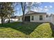 Backyard featuring a well-maintained lawn, complemented by mature trees and a partially fenced perimeter at 15807 Leatherleaf Ln, Land O Lakes, FL 34638