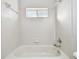 Clean, white tiled shower and bath tub with small window at 15807 Leatherleaf Ln, Land O Lakes, FL 34638