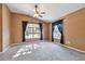 Spacious bedroom featuring plush carpeting, two windows, and a ceiling fan with overhead lighting at 15807 Leatherleaf Ln, Land O Lakes, FL 34638