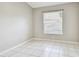 Simple bedroom with a large window and white tile flooring at 15807 Leatherleaf Ln, Land O Lakes, FL 34638