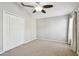 Neutral bedroom with carpet, a ceiling fan, double door closet, and a window at 15807 Leatherleaf Ln, Land O Lakes, FL 34638
