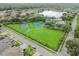 Aerial view of a community offering a pool, playground, basketball and tennis courts near a tranquil lake at 15807 Leatherleaf Ln, Land O Lakes, FL 34638