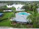 Aerial view of community featuring a pool, playground and pond surrounded by lush landscaping and mature trees at 15807 Leatherleaf Ln, Land O Lakes, FL 34638