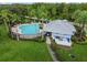 Community pool area with ample seating, a pool house, and mature palm trees in a Gathering neighborhood at 15807 Leatherleaf Ln, Land O Lakes, FL 34638