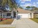 Charming single-story home featuring a two-car garage, well-manicured lawn, and neutral color palette at 15807 Leatherleaf Ln, Land O Lakes, FL 34638