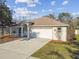 Charming single-story home featuring a two-car garage, well-manicured lawn, and inviting front porch at 15807 Leatherleaf Ln, Land O Lakes, FL 34638