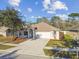 Charming single-story home featuring a well-maintained lawn, inviting front porch, and a two-car garage at 15807 Leatherleaf Ln, Land O Lakes, FL 34638