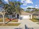 Charming single-Gathering home featuring a well-maintained lawn, a two-car garage, and a welcoming front porch at 15807 Leatherleaf Ln, Land O Lakes, FL 34638