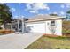 Side view of a single-story home featuring an attached two-car garage and a well-maintained front lawn at 15807 Leatherleaf Ln, Land O Lakes, FL 34638