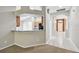Open view of the kitchen and the home's entryway, with a partial wall dividing the space at 15807 Leatherleaf Ln, Land O Lakes, FL 34638