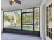 A screened in lanai offers views of the trees, grass and fenced in yard at 15807 Leatherleaf Ln, Land O Lakes, FL 34638