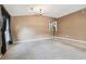Open living area with access to kitchen and dining, featuring carpet and neutral wall color at 15807 Leatherleaf Ln, Land O Lakes, FL 34638