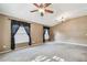 Inviting living room showcasing plush carpeting, neutral-colored walls, and modern ceiling fan with lighting at 15807 Leatherleaf Ln, Land O Lakes, FL 34638