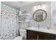 Updated bathroom with stylish vanity, round mirror and tub with starfish shower curtain at 1612 Suffolk Dr, Clearwater, FL 33756