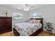 Bright bedroom with stylish coastal bedding, two windows, wood floors, and a decorative dresser at 1612 Suffolk Dr, Clearwater, FL 33756