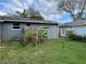 View of the backyard showing a fenced yard with tropical foliage and mature trees at 16240 Lake Palm Dr, Lutz, FL 33549