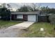 Cozy home featuring a single-car garage and a long concrete driveway at 16240 Lake Palm Dr, Lutz, FL 33549