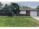 Charming single story home with brick facade, red shutters, and a well-maintained lawn at 16240 Lake Palm Dr, Lutz, FL 33549