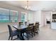 Bright dining room with a modern chandelier, overlooking a lush, landscaped yard through sliding glass doors at 17749 Garsalaso Cir, Brooksville, FL 34604