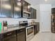 Elegant kitchen with granite counters, stainless steel appliances, and dark brown cabinets at 17749 Garsalaso Cir, Brooksville, FL 34604