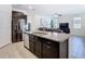 Modern kitchen island with granite countertop, stainless steel sink, and view to the living room at 17749 Garsalaso Cir, Brooksville, FL 34604