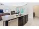 Open kitchen with stainless steel dishwasher and island sink overlooking the living room and dining area at 17749 Garsalaso Cir, Brooksville, FL 34604