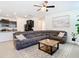 Spacious living room with gray sectional sofa, decorative rug, and adjacent kitchen area at 17749 Garsalaso Cir, Brooksville, FL 34604