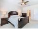 Light-filled main bedroom with carpet, a dark wood bed, and matching nightstands at 17749 Garsalaso Cir, Brooksville, FL 34604