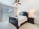 Inviting main bedroom with a dark wood bed frame, soft carpet, and natural light at 17749 Garsalaso Cir, Brooksville, FL 34604