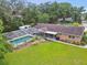 An aerial backyard view showcases the screened-in pool, well-maintained lawn, mature landscaping, and a private outdoor oasis at 1805 Parkwood Dr, Valrico, FL 33594