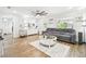 Bright living room featuring wood-look floors, a large gray sofa, and neutral decor at 1805 Parkwood Dr, Valrico, FL 33594