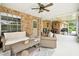 Enclosed patio with brick accent wall, neutral furnishings, and outdoor ceiling fan at 1805 Parkwood Dr, Valrico, FL 33594