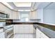 Bright kitchen featuring stainless steel appliances, granite countertops and white cabinetry at 18828 Rue Loire, Lutz, FL 33558