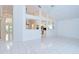Bright living room features tiled floors, views to kitchen, high ceilings with a ceiling fan, and light neutral decor at 18828 Rue Loire, Lutz, FL 33558