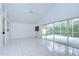 Bright living room features tiled floors, high ceilings with a ceiling fan, and sliding glass doors to the patio at 18828 Rue Loire, Lutz, FL 33558