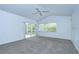 Bright main bedroom features carpeted floors, high ceilings with a ceiling fan, and sliding glass doors to the patio at 18828 Rue Loire, Lutz, FL 33558