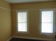 Neutral bedroom with two bright windows, providing natural light and a cozy atmosphere at 2506 1/2 E Columbus Dr, Tampa, FL 33605