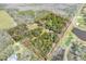 Expansive lot with mature trees, including lakes, golf course, and a house with pool surrounded by natural beauty at 2690 E Lake Trl, Tarpon Springs, FL 34688