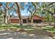 Exterior of a home featuring a driveway, mature trees, and an attached garage at 2690 E Lake Trl, Tarpon Springs, FL 34688