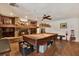 Spacious game room with a brick fireplace, pool table, and hardwood floors, perfect for entertaining guests at 2690 E Lake Trl, Tarpon Springs, FL 34688