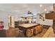 A view of the game room leading into an open floorplan kitchen and dining area with hardwood floors throughout at 2690 E Lake Trl, Tarpon Springs, FL 34688