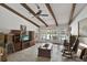Bright living room with exposed beam ceilings, neutral walls, concrete floors, and french doors to the outdoors at 2690 E Lake Trl, Tarpon Springs, FL 34688