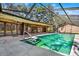 A stunning pool surrounded by an enclosure, with lots of natural light and steps leading to a deep end at 2690 E Lake Trl, Tarpon Springs, FL 34688